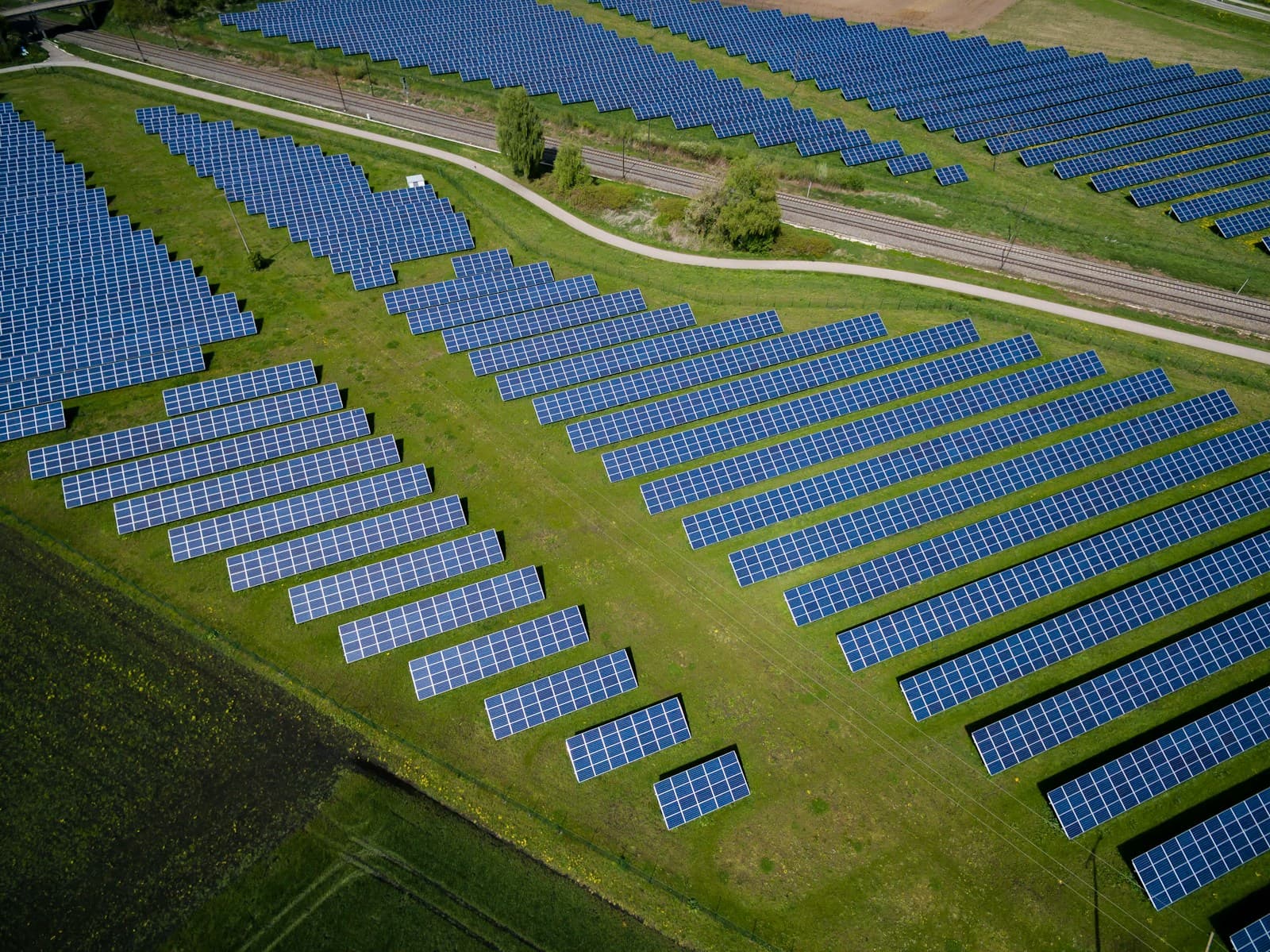 Aerial view of a solar panel farm across a green field in Germany