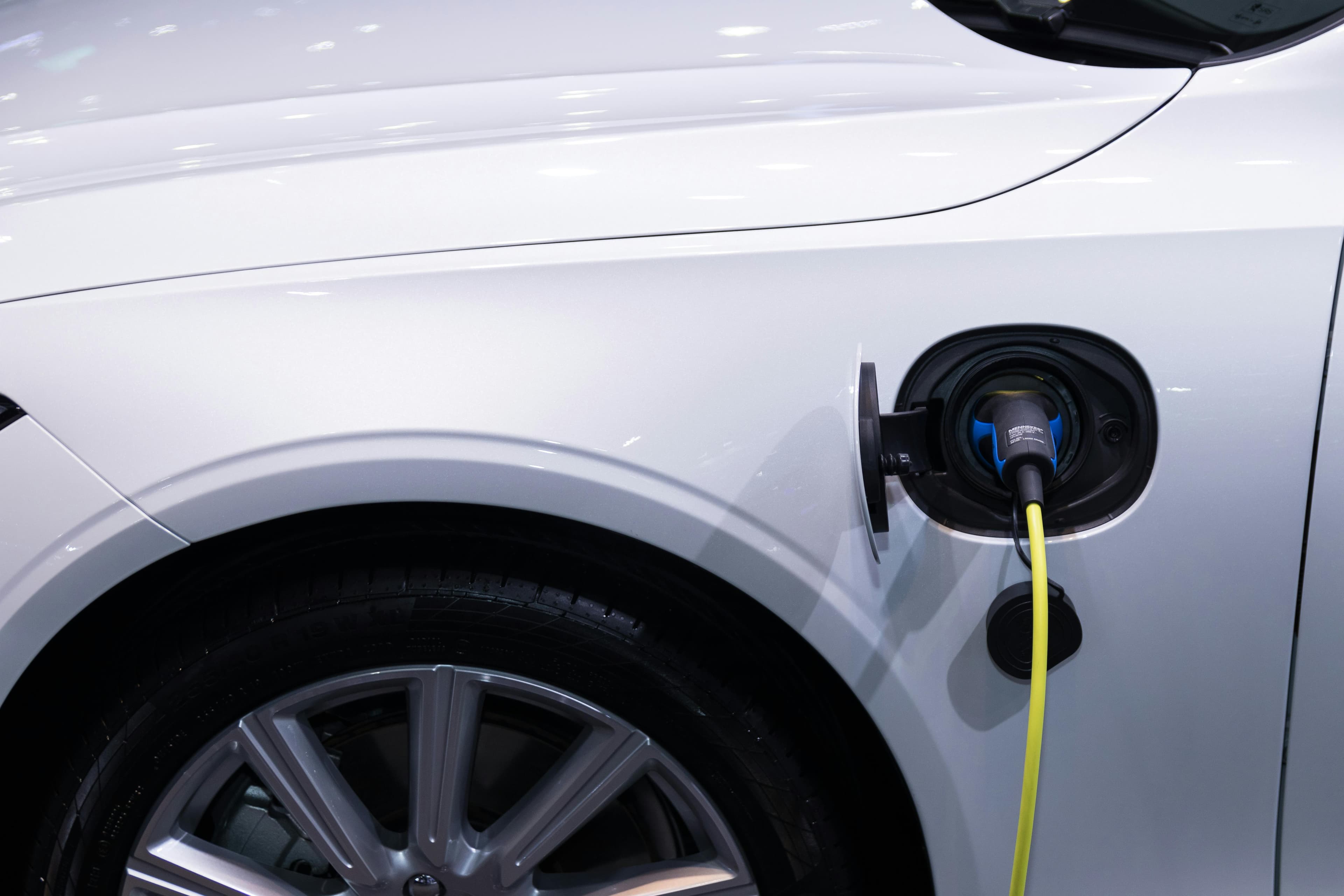 White electric car connected to a charging station