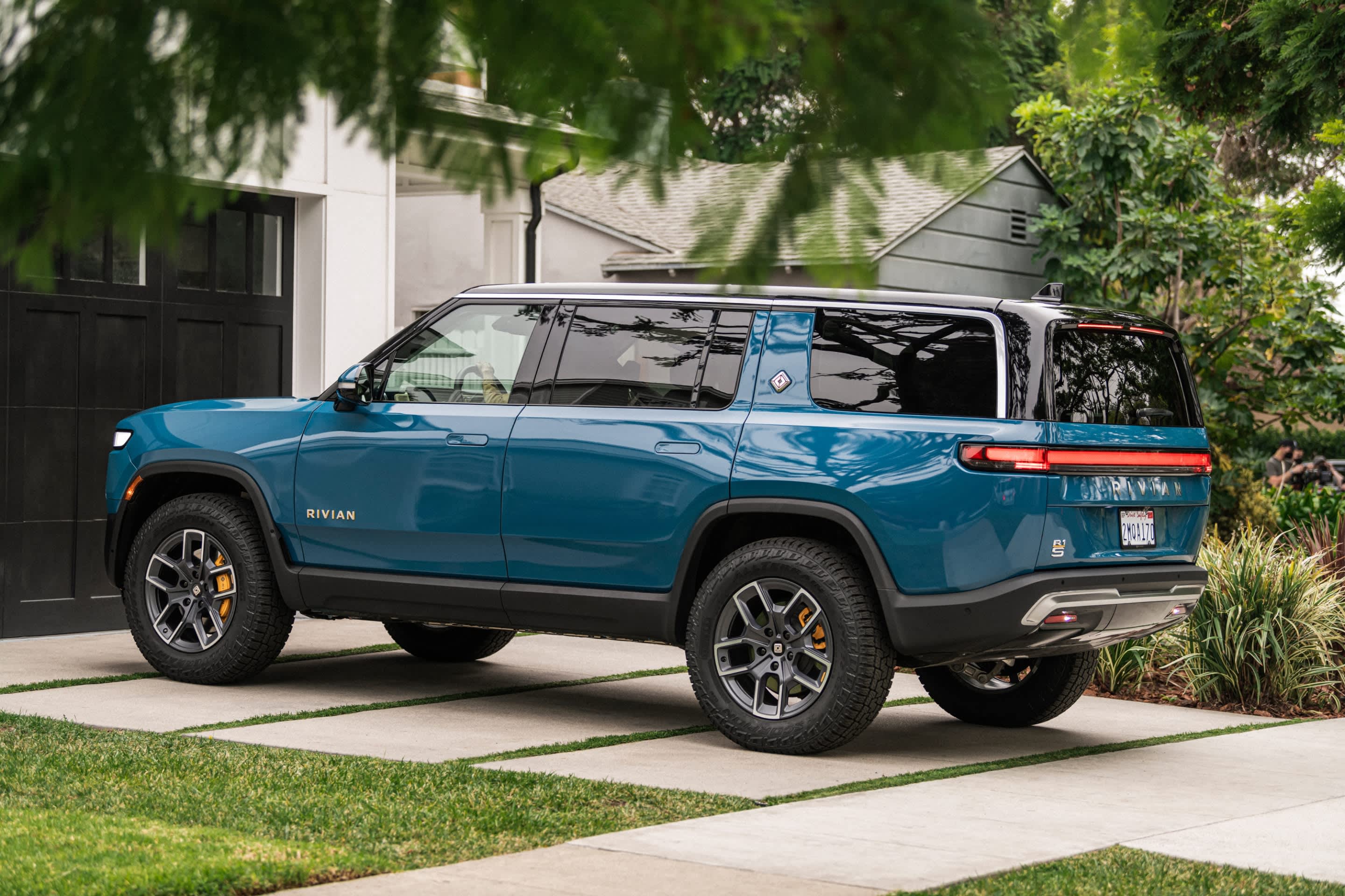 Rivian R1T electric pickup truck parked in a residential driveway
