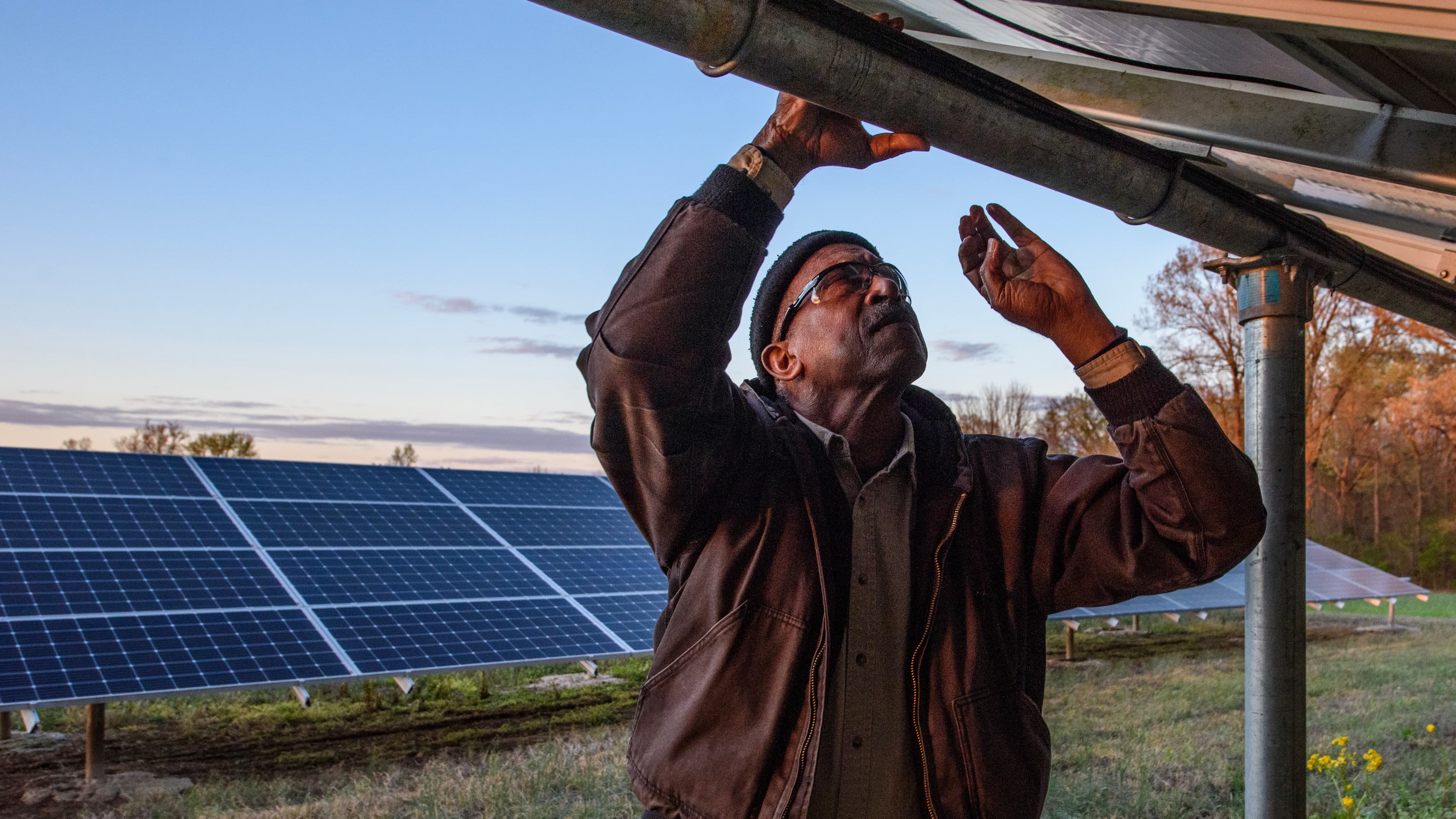 Aaron Webb inspecting solar panels at his USDA REAP-funded farm in Humboldt, Tennessee